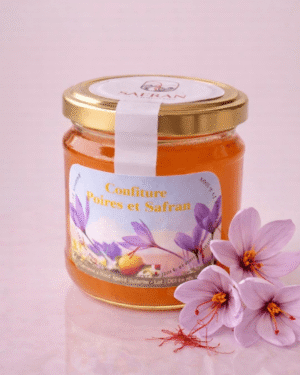 Vue sur un pot de confiture de poires au safran à côté de trois fleurs de safran et quelques stigmates rouges