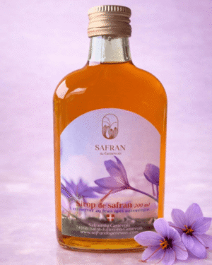 Vue sur une bouteille de sirop au safran avec à ses côtés deux fleurs de safran violette
