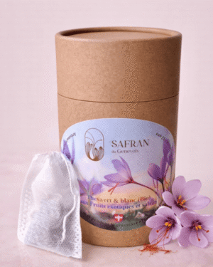 Boîte en carton contenant du thé vert et blanc au safran et fruits exotiques à côté de trois fleurs de safran et quelques stigmates rouges